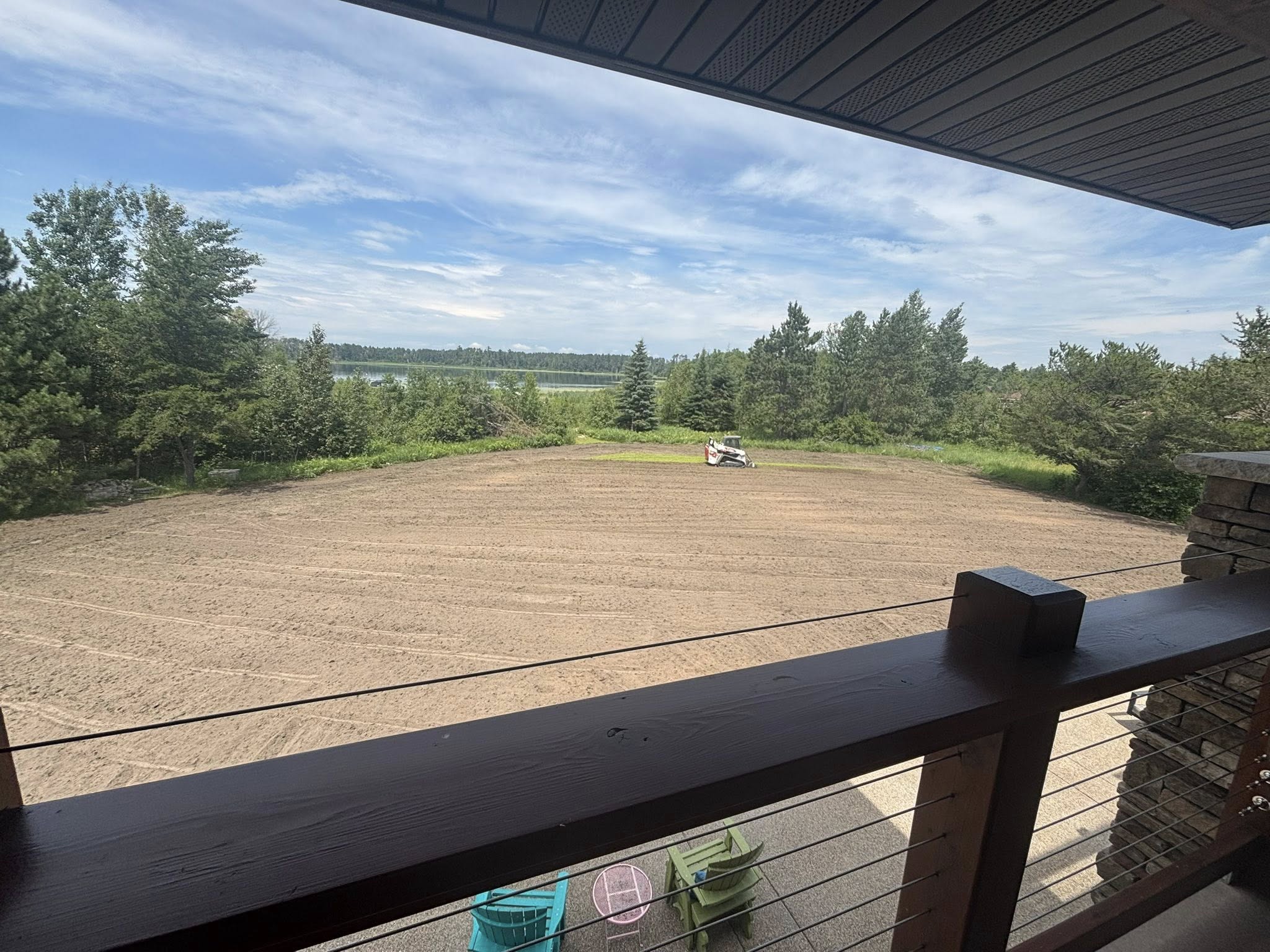 Bobcat T770 actively working in graded yard with lake view